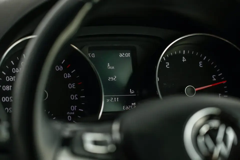 A car dashboard thermometer showing a high temperature reading