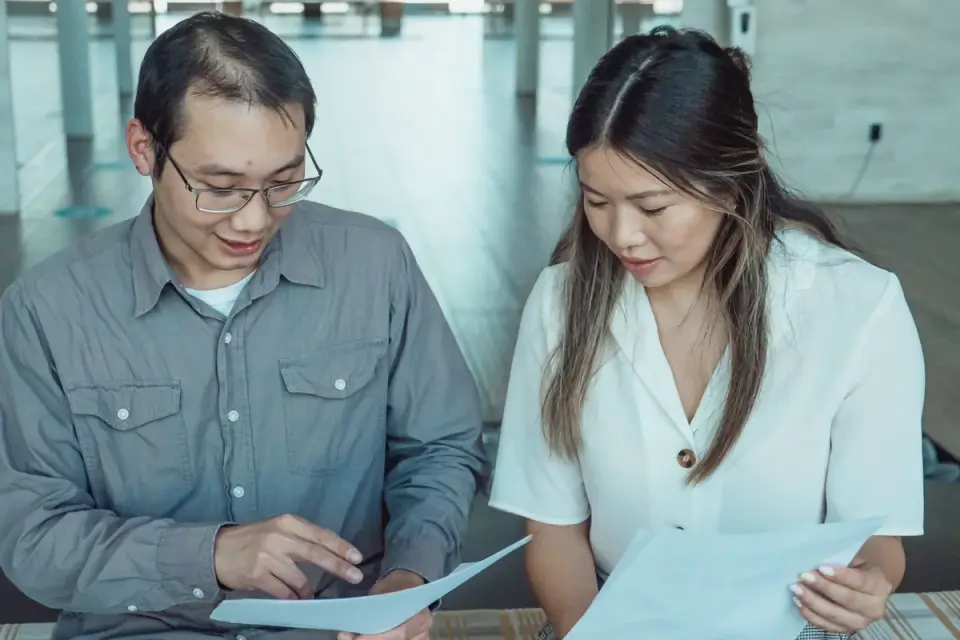 A dog owner going over travel paperwork with a veterinarian at a clinic desk