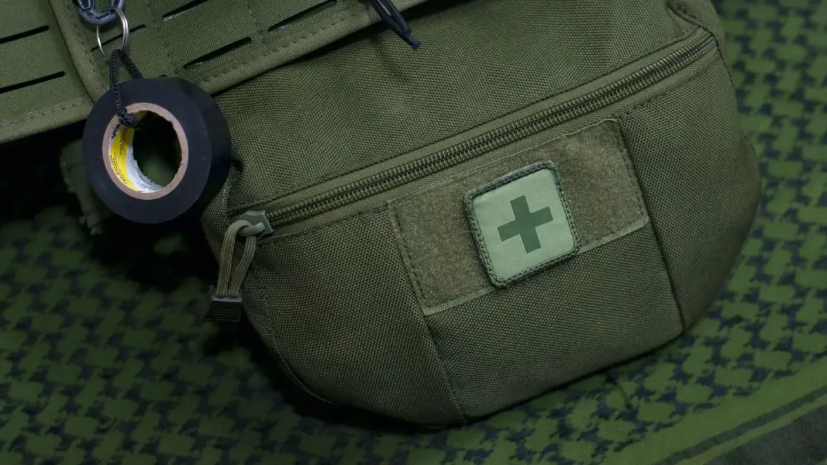 A packed travel bag for a dog sitting open on a car seat, showing a leash, collapsible bowl, and first aid pouch