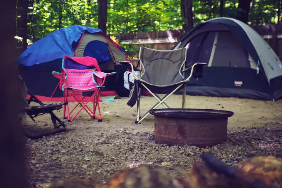 Family sitting near a tent with a leashed dog resting beside them
